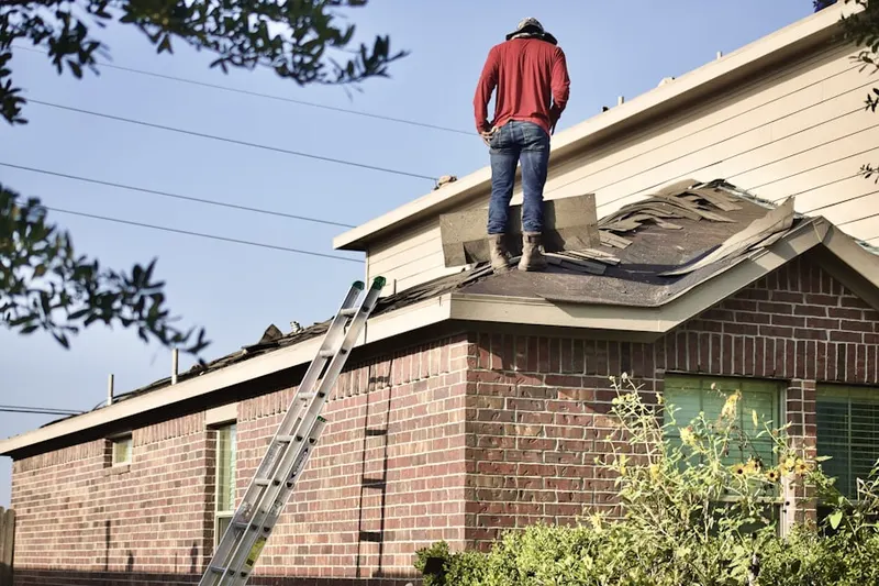 Professional roofer working on a residential roof in Wingate